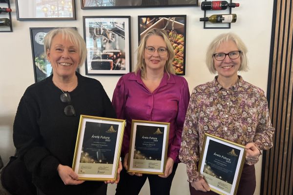 tre leende kvinnor med diplom