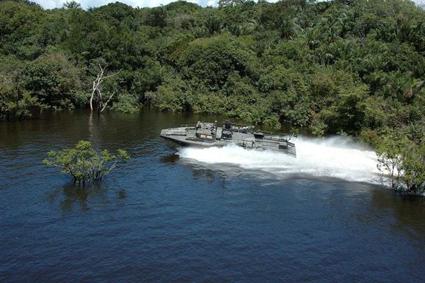En stridsbåt i en flod i en djungel